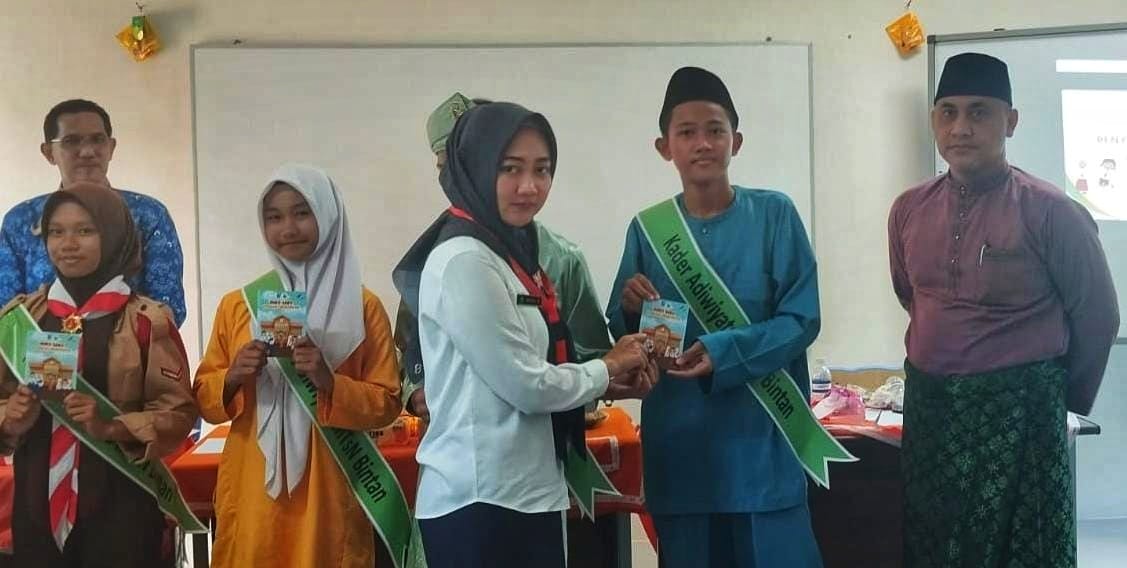 Beberapa siswa menerima buku saku literasi lingkungan yang dibagikan DLH Bintan, Selasa (21/10).