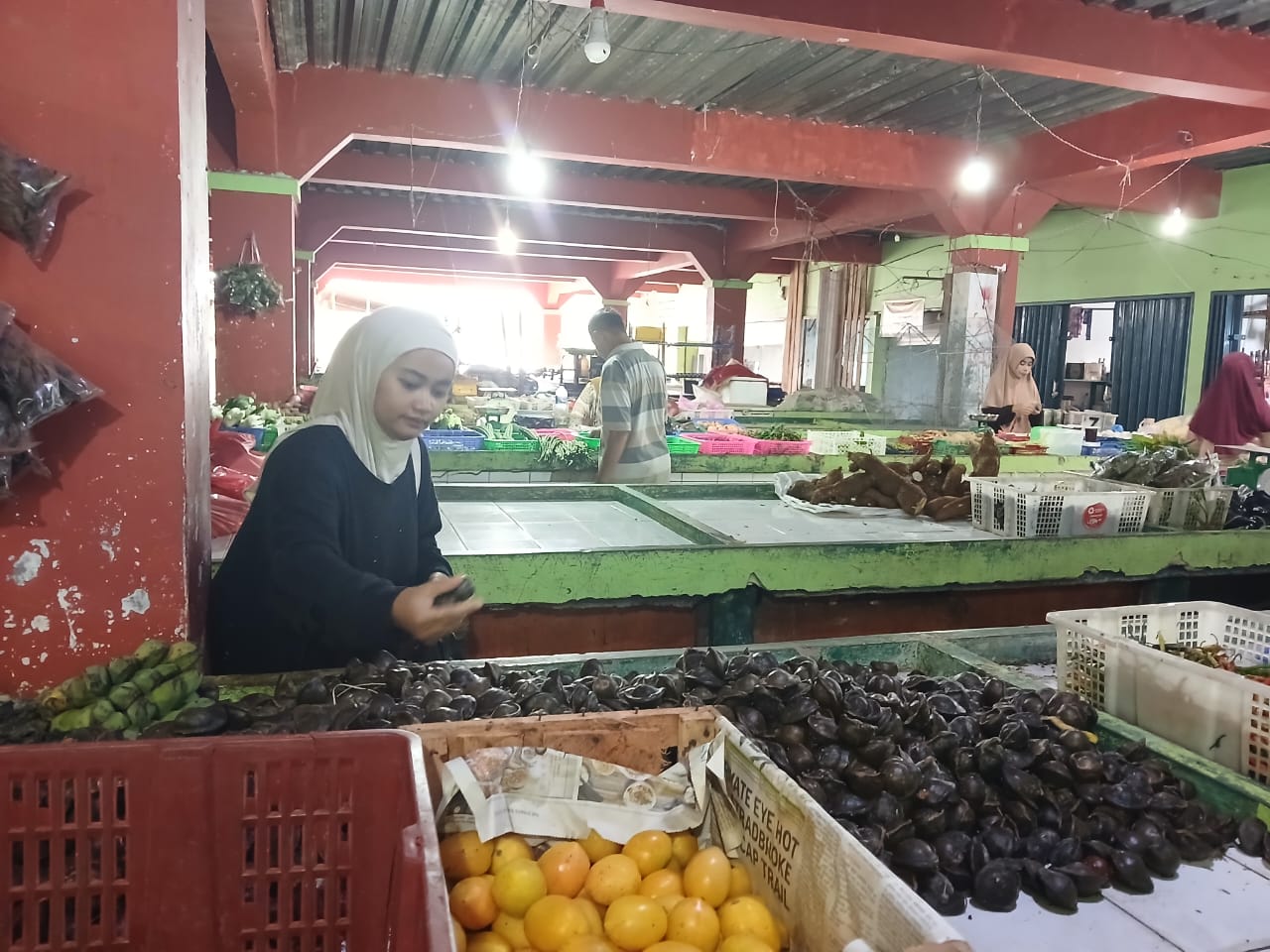 Terlihat salah satu pembeli sedang memilih jengkol di Pasar Tanjung, Desa Tarempa Barat. Pedagang setempat minta Pemda hidupkan kembali pasar tersebut.