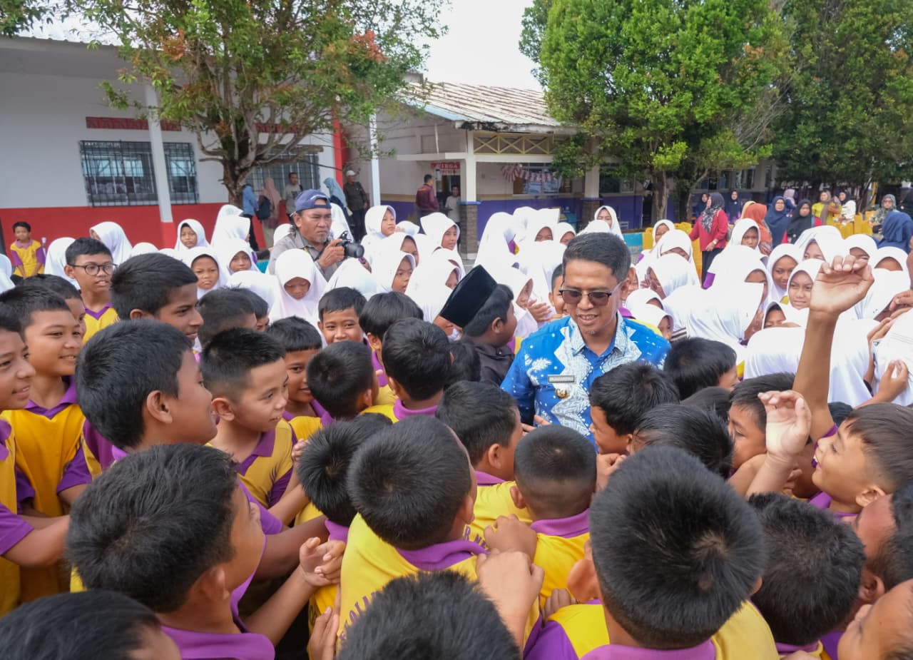 Bupati Karimun didatangi pelajar untuk bersalaman saat pembagian seragam gratis.