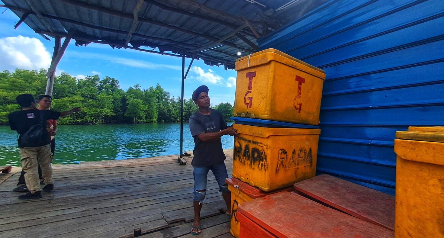 Seorang pekerja sedang menyusun fiber yang diduga digunakan sebagai tempat penyimpanan ikan di pelabuhan rakyat di Jalan Sei Enam Laut, RT 001 RW 002, Kelurahan Sei Enam, Kecamatan Bintan Timur.