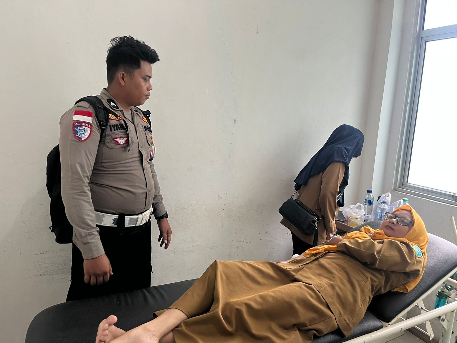 Petugas Satlantas Polres Anambas saat menjenguk salah satu ASN yang alami kecelakaan karena nekat terobos hujan deras.