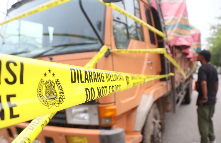 Lima truk dan kontainer dipasang garis polisi berada di depan Kapolresta Barelang, Selasa(11/11). Kelima truk tersebut yang bermuatan barang impor bekas diamankan Polresta Barelang di wilayah sagulung