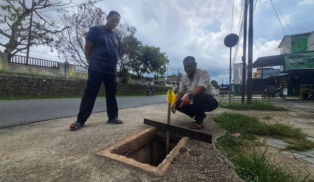 Warga menunjuk ke arah lubang yang besi penutup paritnya hilang diduga dicuri di jalan Taman Sari, Tanjunguban, Kecamatan Bintan Utara, Jumat (14/11).