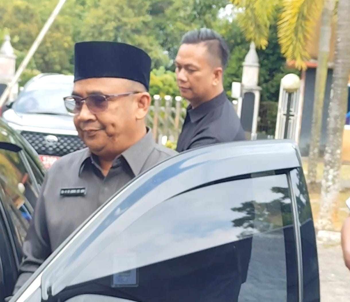 Sekwan DPRD Tanjungpinang, M. Amin saat terburu-buru masuk ke dalam mobil saat dimintai tanggapan pemeriksaan oleh Polda Kepri, Selasa (18/11).