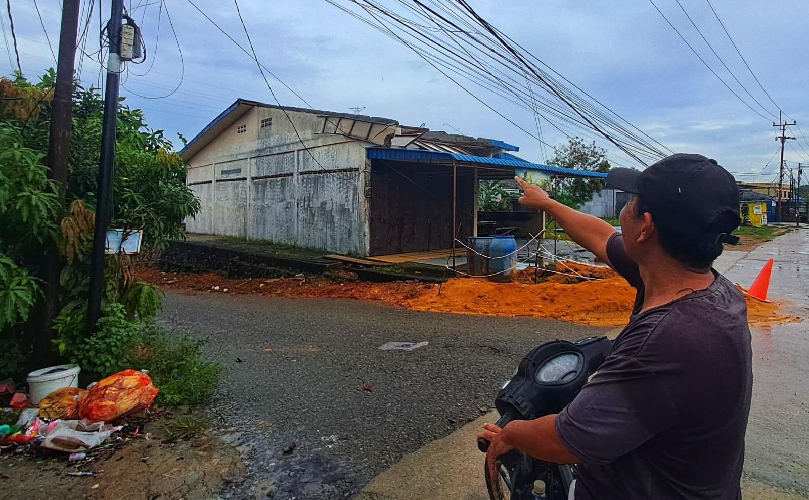 Warga menunjuk bagian atap kedai kopi yang rusak setelah diterbangkan angin kencang disertai hujan deras di Desa Teluk Sasah, Kecamatan Seri Kuala Lobam, Rabu (19/11) malam.