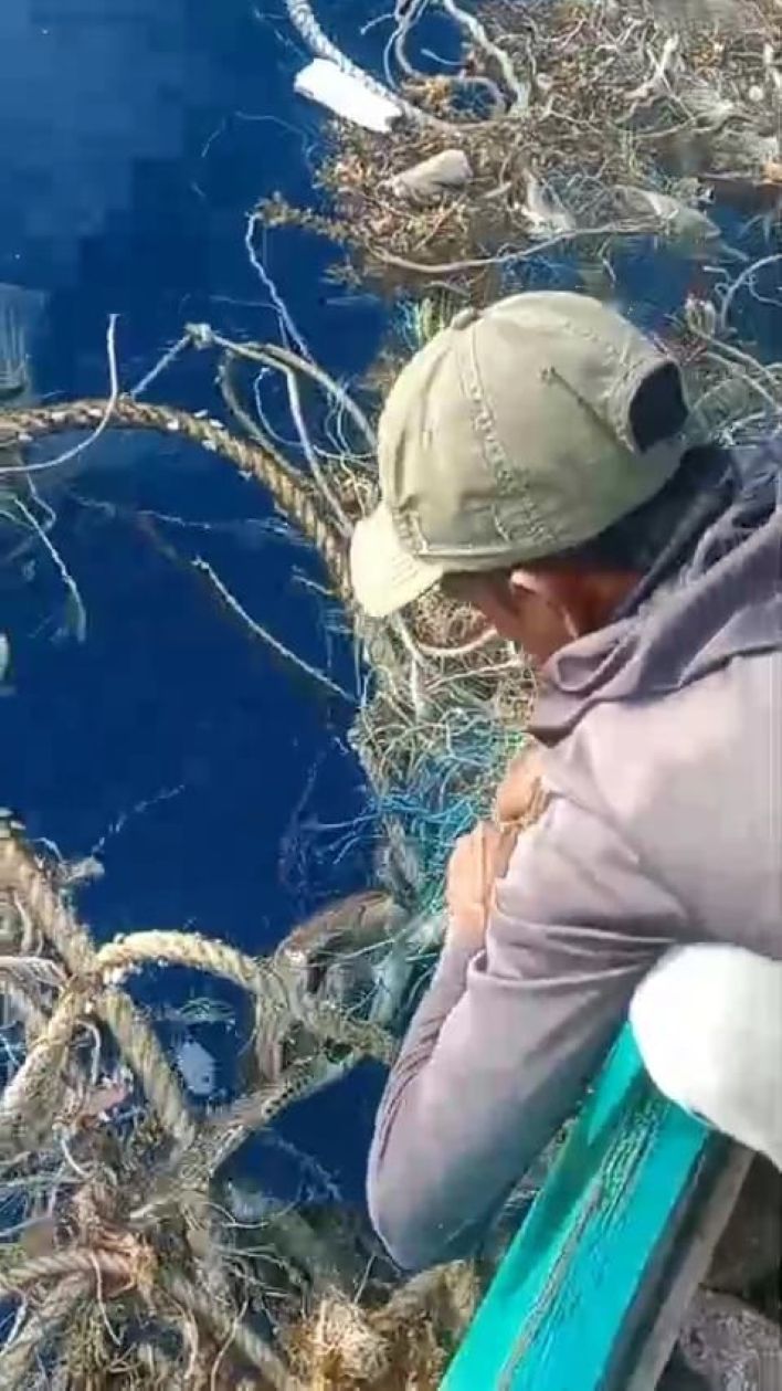Nelayan saat menyelamatkan penyu yang terjebak dipusaran sampah dan jaring di Teluk Sadang, Jemaja Barat.