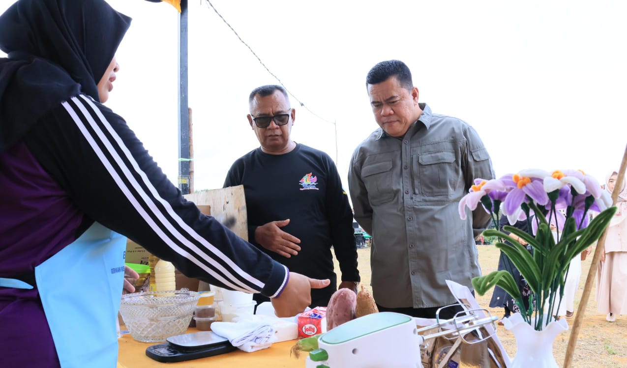 Sekda Bintan, Ronny Kartika bersama Kades Sri Bintan, Prayitno melihat dari dekat kreasi kuliner yang disajikan dalam Festival Budaya dan Kuliner 2025 Lapangan Bola Kaki Poyotomo Desa Sri Bintan.