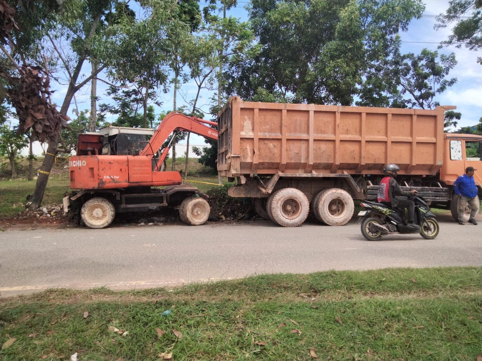 Satgas sampah menurunkan alat berat untuk mempermudah pengangkutan sampah.
