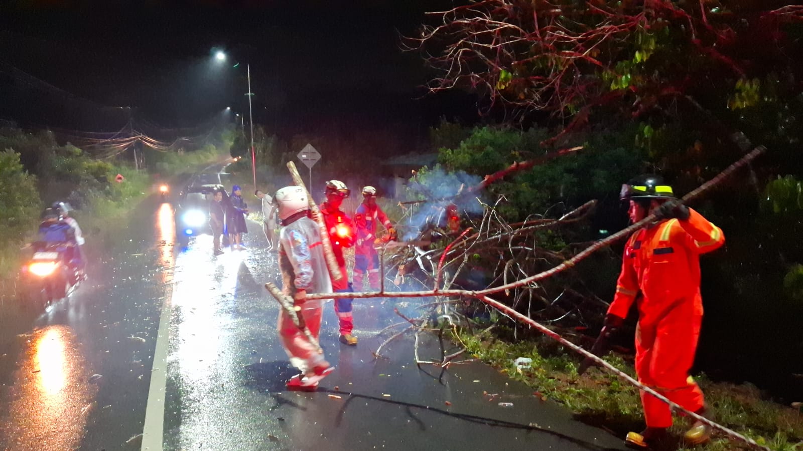 Petugas Damkar Tanjunguban memindahkan pohon yang tumbang dan melintang di jalan Manggar, Kampung Bugis, Tanjunguban, Kecamatan Bintan Utara, Jumat (28/11) malam.