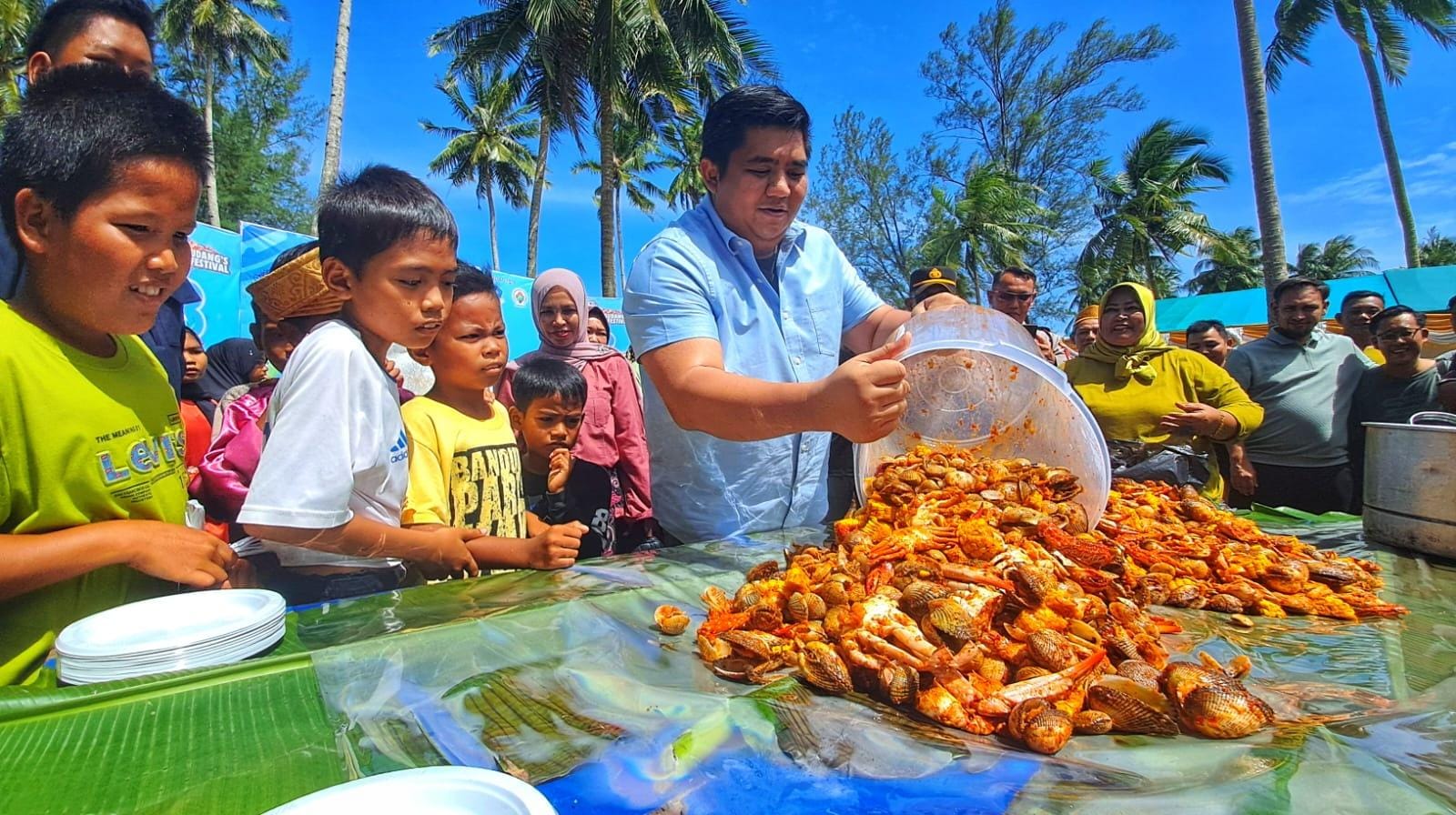 Masyarakat termasuk anak-anak bersemangat untuk berebut mengambil seafood tumpah yang dituang oleh Bupati Bintan, Roby Kurniawan dalam acara Pengudang Seafood Festival di Batumpang, Desa Pengudang.