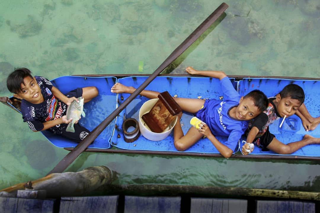 Tiga kawanan anak Tarempa, Randi, Bagas dan Hairul melemparkan senyuman dari atas Jongkong transportasi untuk memancing, Minggu, (30/11).