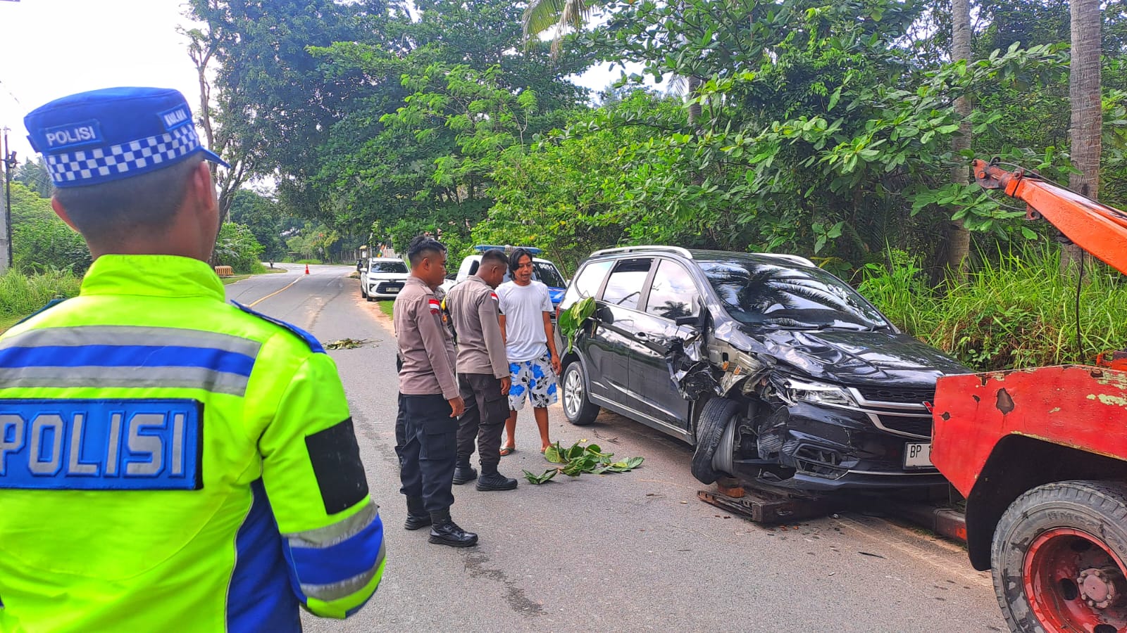 Petugas Kepolisian mengevakuasi mobil Wuling yang terlibat kecelakaan dengan sepeda motor di jalan raya Pantai Trikora, Kilometer (Km) 42, Kampung Mengkurus, Desa Teluk Bakau, Kecamatan Gunung Kijang