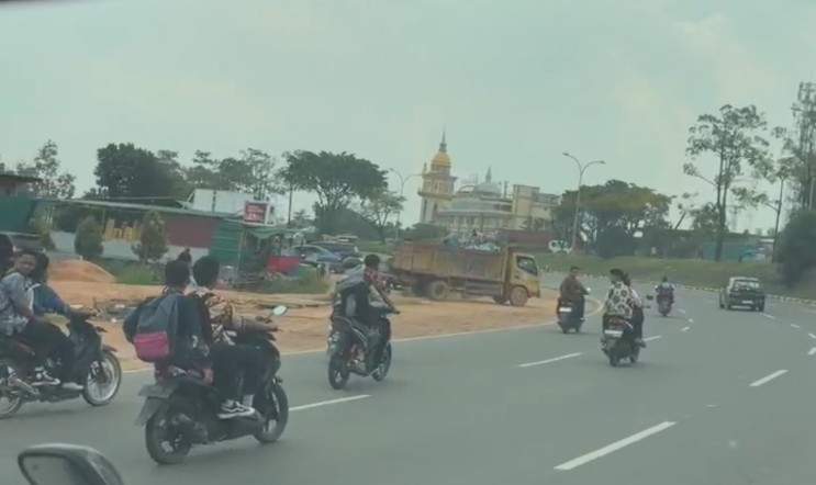 Sejumlah pelajar mengendarai motor tanpa helm sambil melakukan standing di Jalan Yos Sudarso menuju Seraya Atas, Senin (1/12).