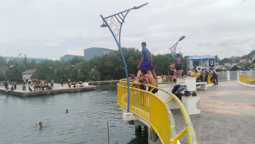 Pelantar Tanjung Riau mendadak berubah menjadi waterpark dadakan saat air laut pasang besar. Warga dan puluhan pelajar berbondong-bondong datang untuk mandi, bahkan ada yang membawa gitar.
