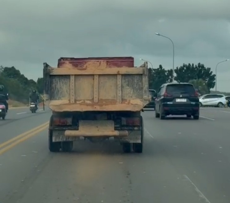 Lori pengangkut tanah saat melintas di jalan raya.