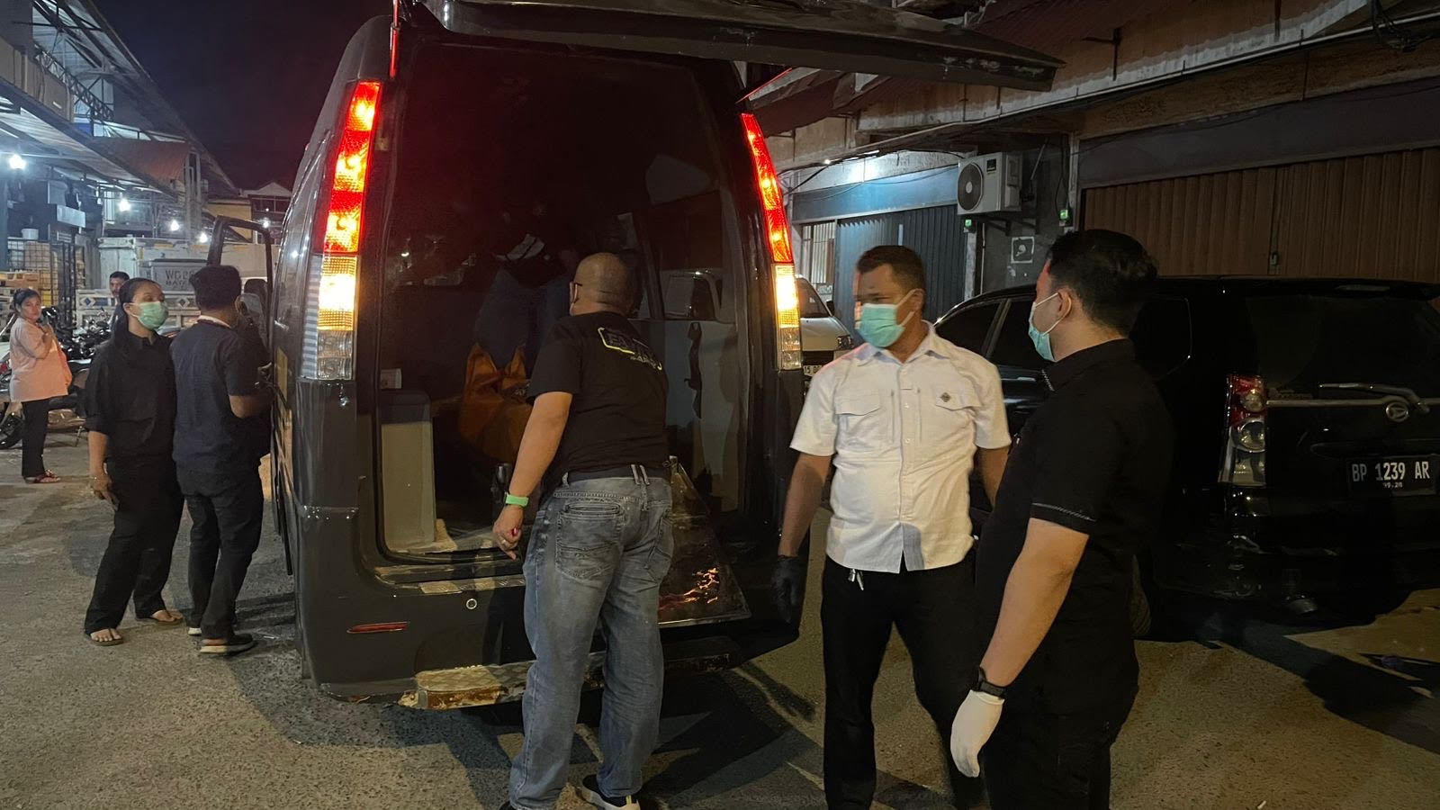 Petugas saat mengevakuasi jenazah pengamen