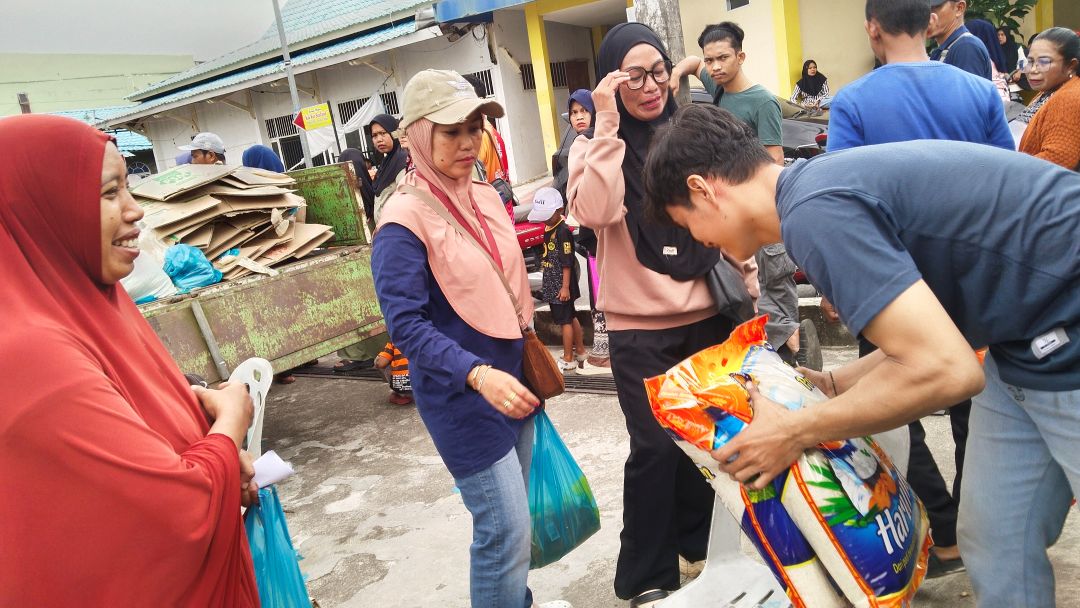 Warga Sekupang antre menunggu pembagian paket sembako bersubsidi di halaman Masjid Jami Nurul Huda, Rabu (10/12).