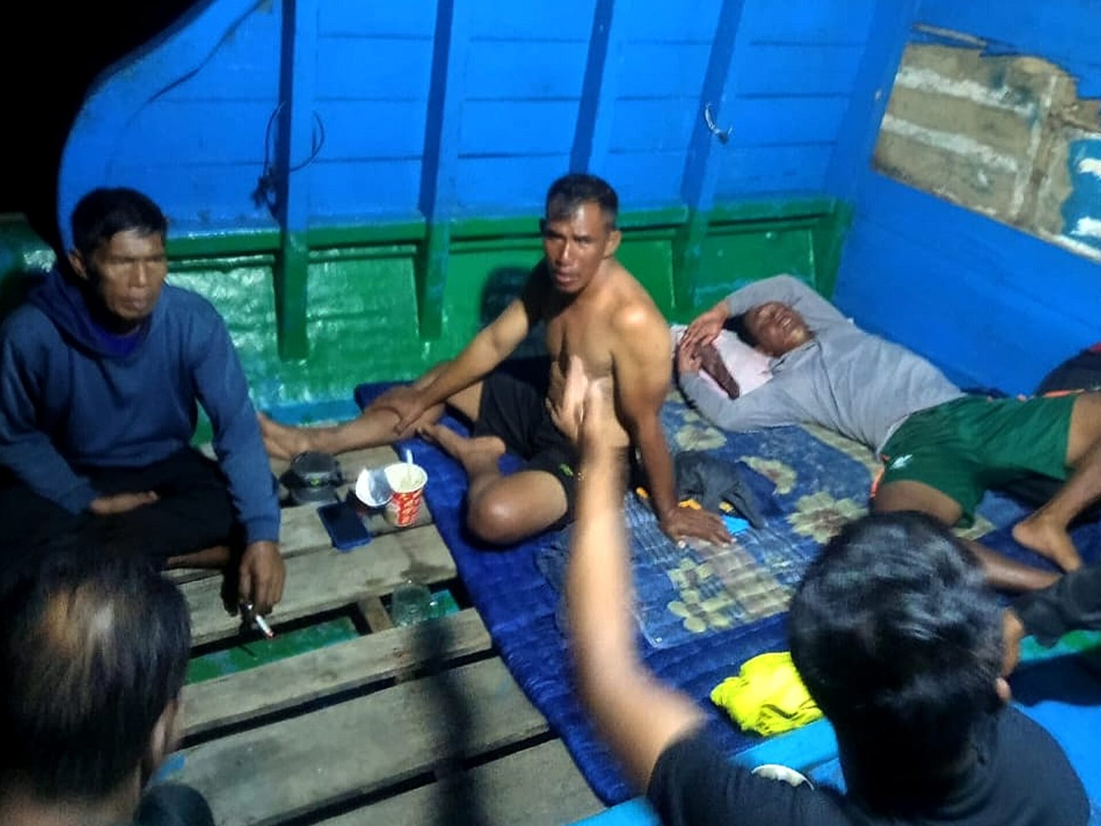 Salah satu awak kapal KM Pelangi 15, Juraimi (tak pakai baju) saat sedang menceritakan kejadian yang dialami kepada tim penyelamat.