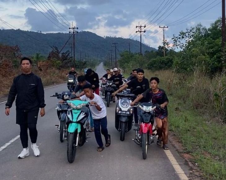Pebalap yang didominasi usia anak dan remaja mendorong sepeda motornya setelah terjaring penertiban aksi balap liar di jalan Kampung Banjar, Desa Gunung Kijang, Kecamatan Gunung Kijang, Jumat (12/12).