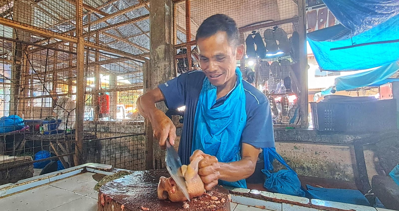 Pedagang memotong daging ayam pesanan pembeli di Pasar Baru Tanjunguban, Kecamatan Bintan Utara, Selasa (23/12/2025).  Harga Ayam Potong Turun, Daging Beku Naik