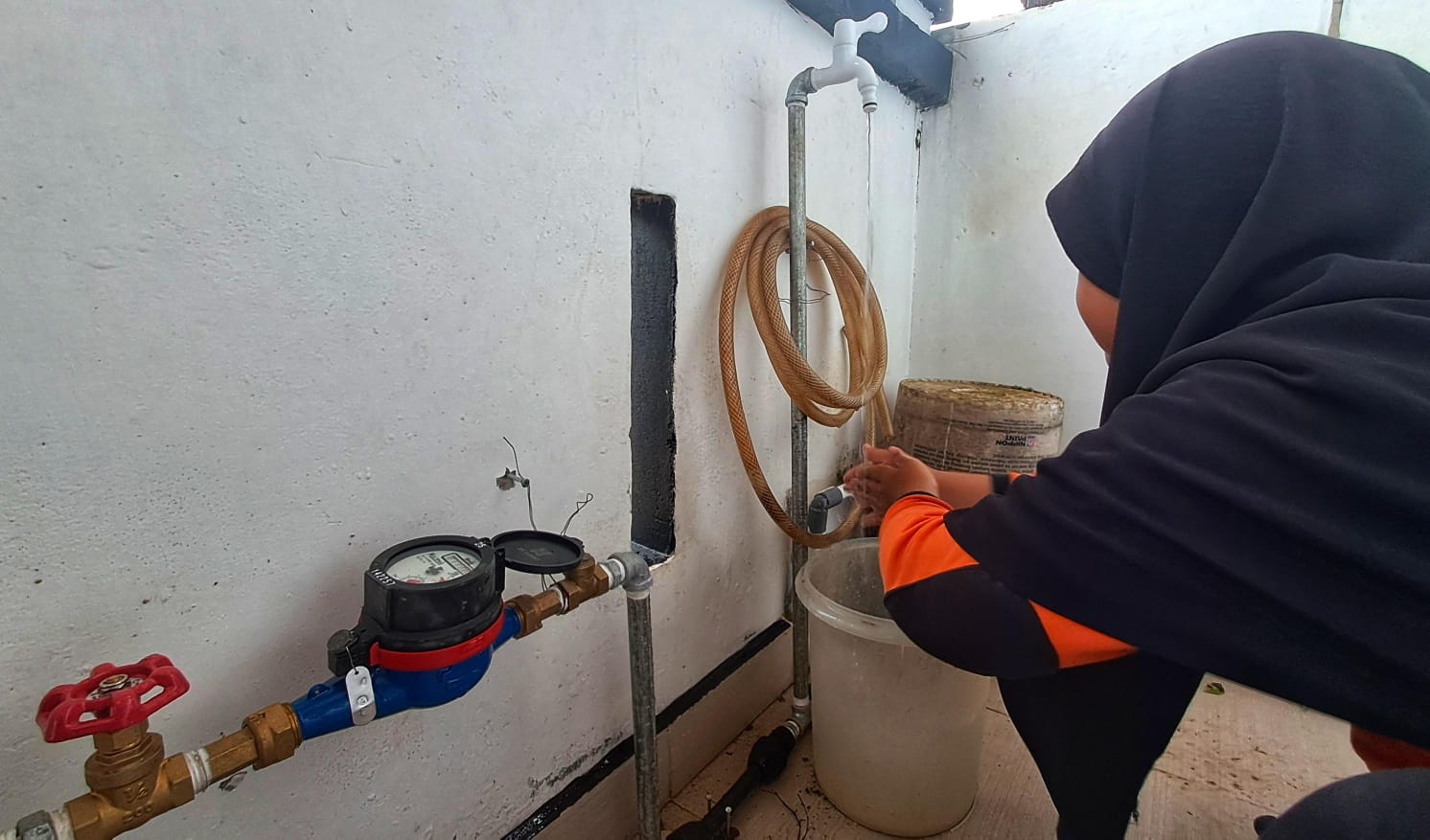 SALAH satu warga memperhatikan air mengalir dari keran di rumahnya di Perumahan Lobam Mas Asri, Desa Teluk Sasah, Kecamatan Seri Kuala Lobam, Kamis (8/1/2026). F.Slamet Nofasusanto/Batam Pos.