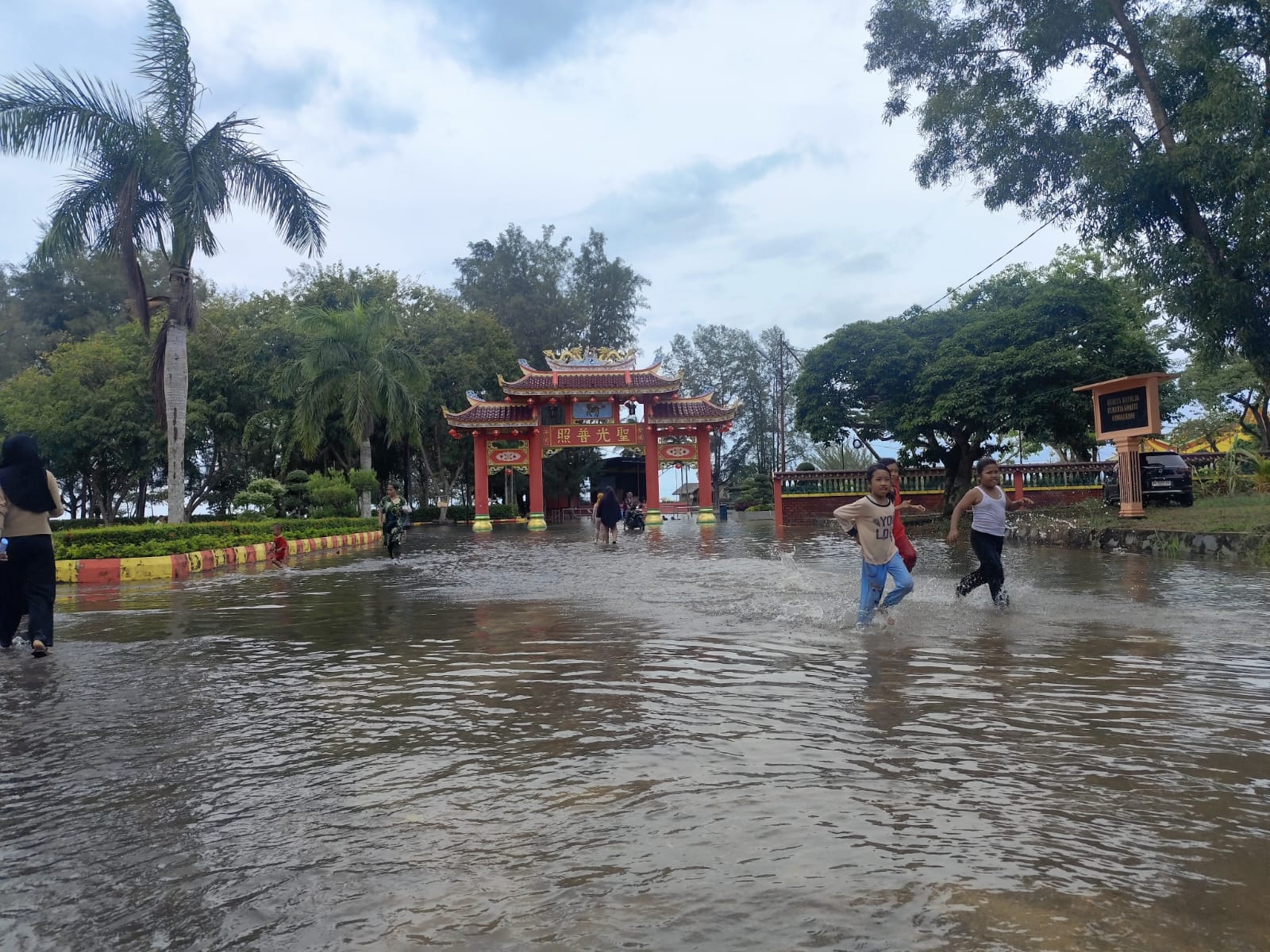 WARGA beramai-ramai bermain di Vihara Dharma Sasana yang terendam banjir, Kamis (8/1). F. Mohamad Ismail/Batam Pos