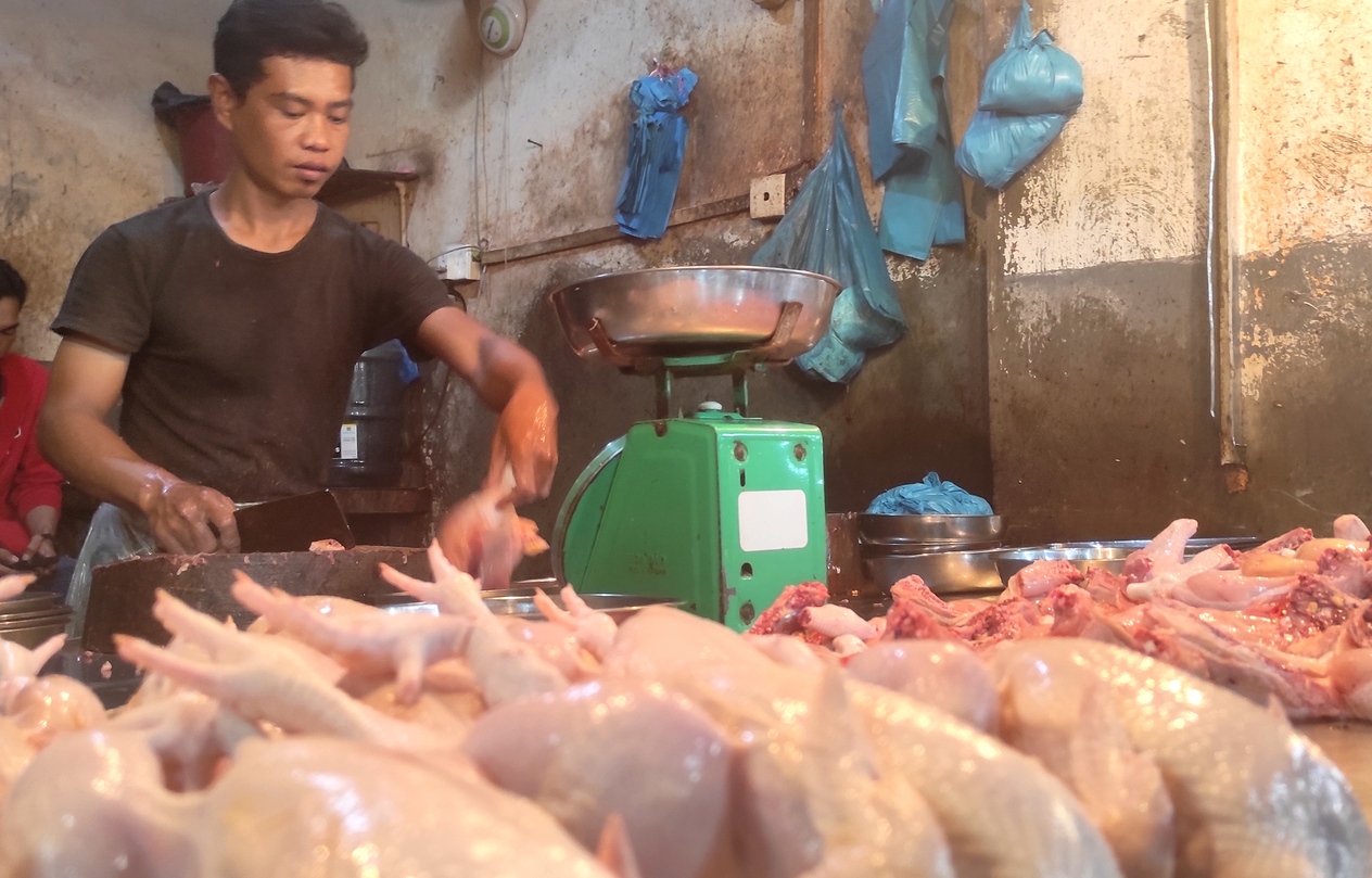 Pedagang ayam potong di Pasar Mega Legenda menyiapkan ayam yang dipesan konsumen, Minggu (22/12). Saat ini harga daging ayam potong di Batam masih tinggi.