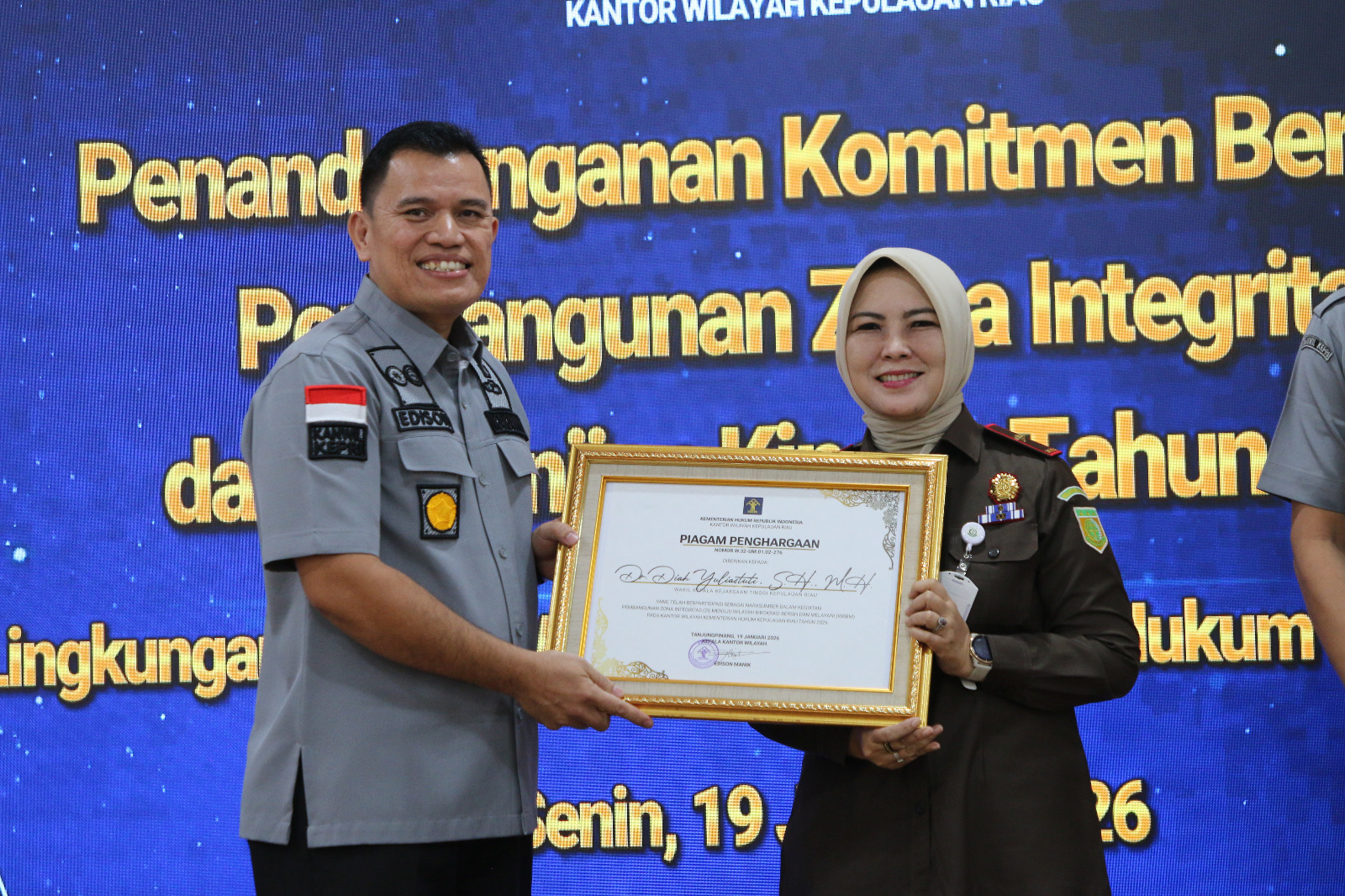 KAKANWIL Kemenkum Kepri, Edison Manik saat memberikan piagam penghargaan kepada Wakajati Diah Yuliastuti. F. Kemenkum Kepri untuk Batam Pos
