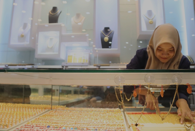 Seorang karyawan toko emas Banda Baru Mega mall sedang menyusun emas yang dipajang, Rabu (21/1). Harga emas terus mengalami kenaikan.