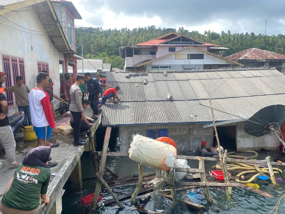 Petugas dan warga memantau puing-puting rumah milik Yono yang ambruk ke laut diterjang angin kencang, Minggu, (25/1). F. Ihsan Imaduddin/Batam Pos