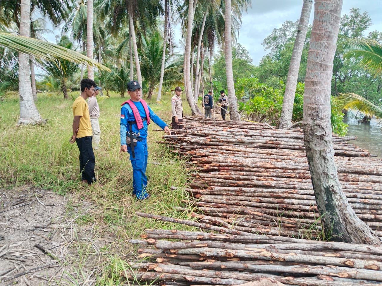 ANGGOTA Satpolairud Polres Lingga saat mengamankan sisa kayu bakau yang berada di Desa Tanjung Kelit, Minggu (26/1). F. Iptu Lundu Herryson untuk BATAM POS
