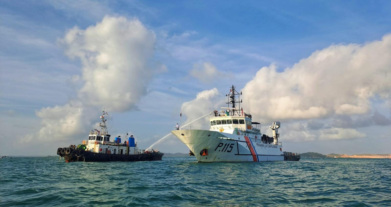 KN Kalimasadha P 115 menyemprotkan air dari anjungan  ke kapal yang terbakar di perairan Tanjunguban saat simulasi penanggulangan pencemaran laut, Senin (26/1/2026). F.Slamet Nofasusanto/Batam Pos