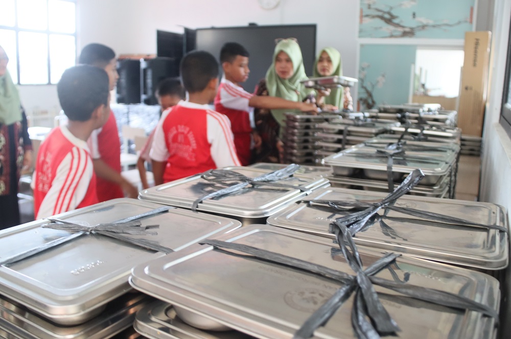 Seorang guru saat akan membagikan Makan Bergizi Gratis (MBG) kepada murid-murid SD 010 Batam Kota babarapa waktu lalu. F.  Cecep Mulyana/Batam Pos