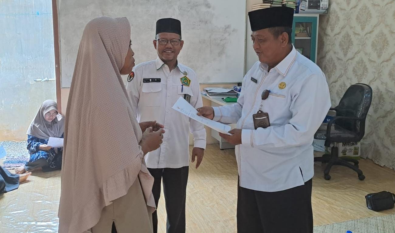 KEPALA Kantor Kemenag Bintan, Abu Sufyan saat menyerahkan sertifikat halal kepada pelaku UKM di Kampung Bukit Batu, Desa Bintan Buyu, Kecamatan Teluk Bintan, Selasa (27/1/2026). F.Hatiman untuk Batam
