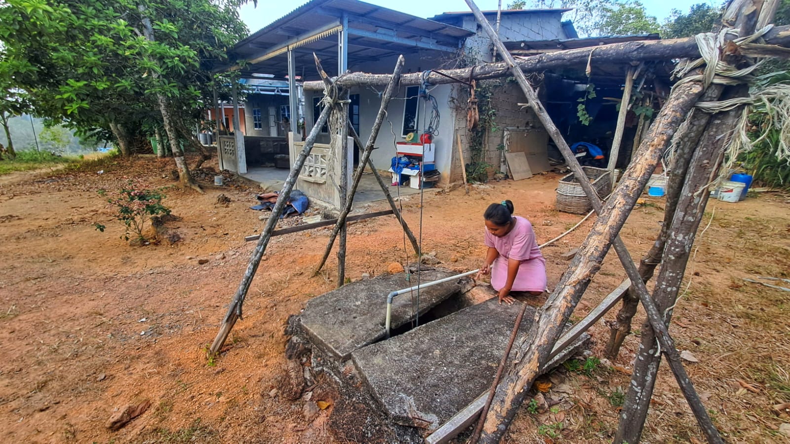 Heni, warga Kampung Sungai Jeram menunjukkan kondisi sumurnya yang mulai mengering. F.Slamet Nofasusanto/Batam Pos