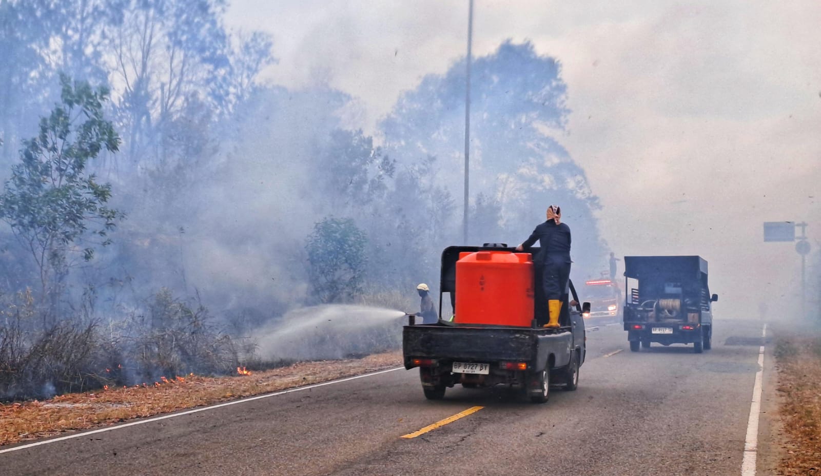 PETUGAS Damkar berusaha memadamkan api di jalan raya Busung, Rabu (28/1/2026) lalu. Warga diminta waspada dan jangan membuka lahan dengan cara dibakar. F.Slamet Nofasusanto/Batam Pos