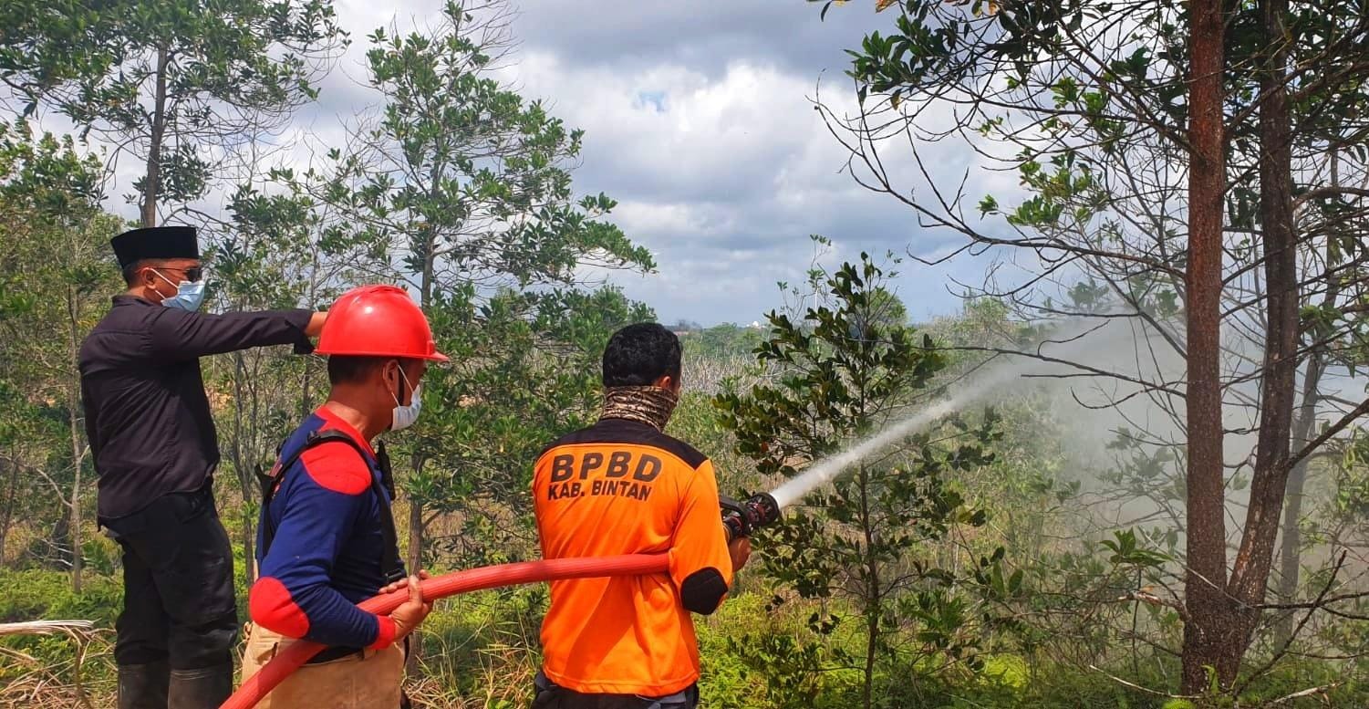 PERSONEL Damkar Toapaya memadamkan api yang membakar lahan di Kecamatan Gunung Kijang, Jumat (30/1/2026). F.Slamet Nofasusanto/Batam Pos.