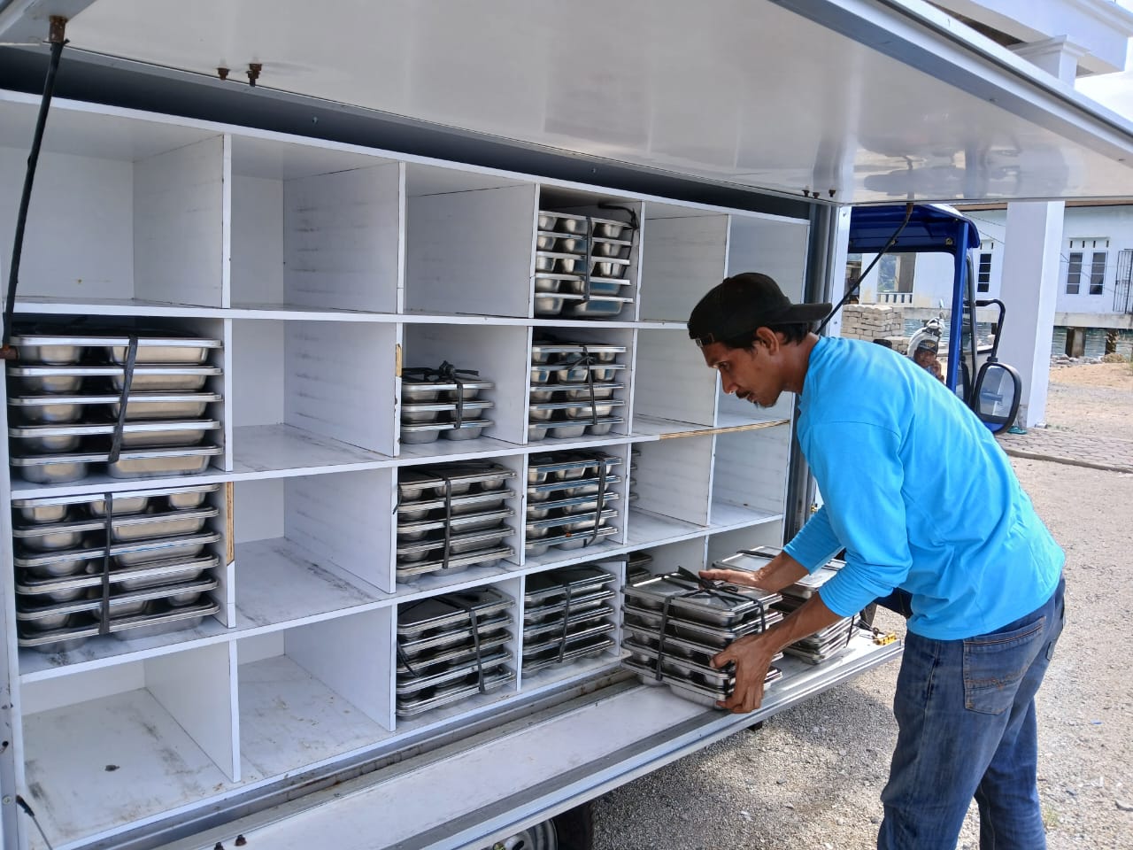 RELAWAN MBG di Air Asuk sedang menurunkan ompreng makanan usai didistribusikan ke penerima manfaat. Pemkab Anambas menekankan agar SPPG harus menyerap hasil pangan dari masyarakat lokal. F Ihsan/BP