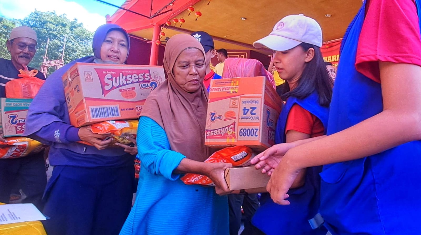PARA anak muda dari Patria turut membantu membawakan paket sembako yang diterima warga saat kegiatan bakti sosial di Vihara Dharma Shanti Tanjunguban, Bintan, Minggu (1/2/2026). F.Slamet Nofasusanto