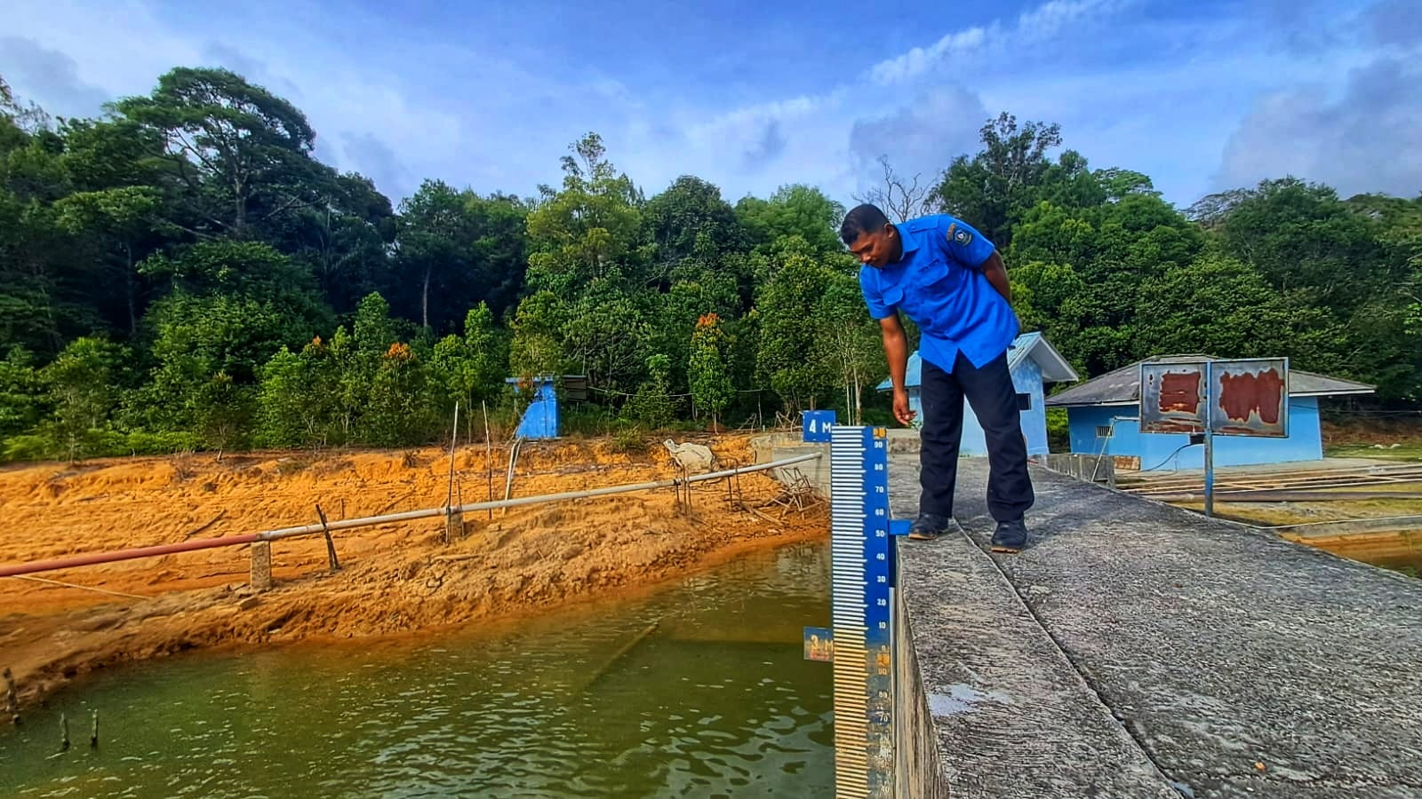 Petugas PDAM Tirta Kepri Cabang Tanjunguban mengecek kondisi ketinggian air di waduk Sei Jago Tanjunguban, Bintan. F.Slamet Nofasusanto/Batam Pos