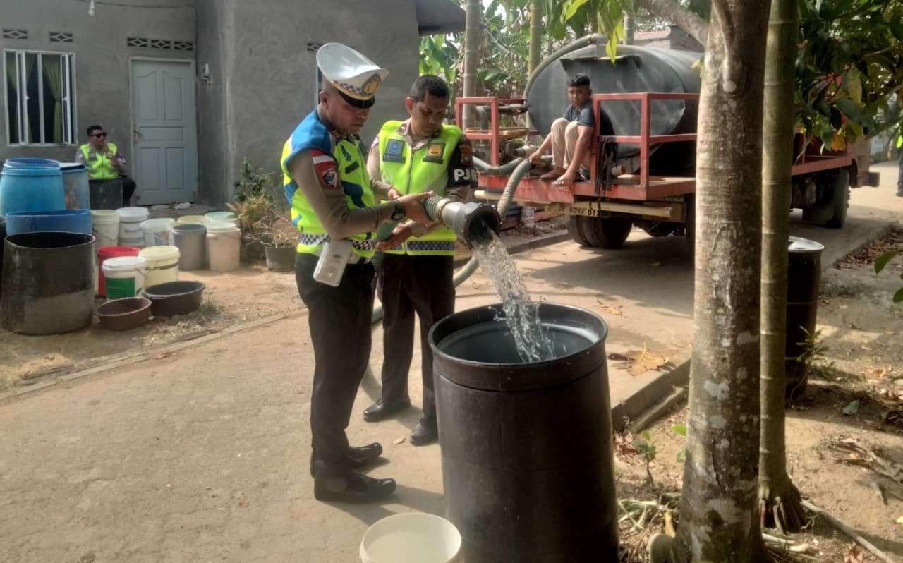 POLISI Petugas Patroli Jalan Raya menyalurkan air bersih di kawasan Gunung Lengkuas, Bintan Timur. F. Satuan PJR Ditlantas Polda Kepri