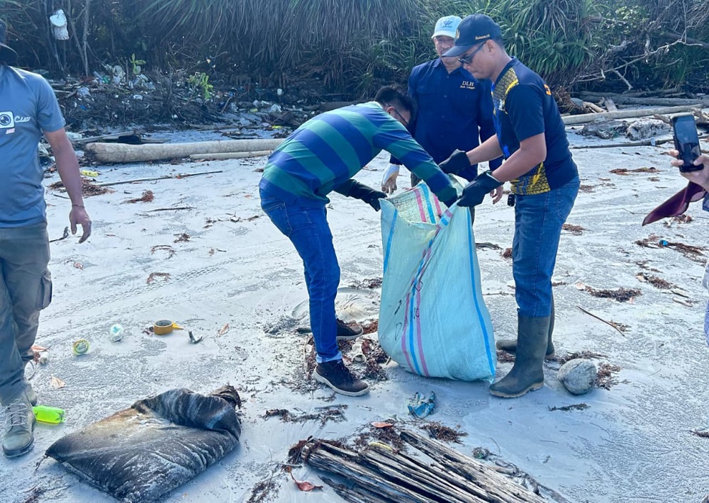 Dinas Lingkungan Hidup Kabupaten Lingga bersama aparat Desa dan masyarakat Belungkur mengumpulkan karung-karung diduga berisi limbah B3 di Pantai Dungun, Sabtu (7/2). F. Djoko Wiyono untuk Batam Pos