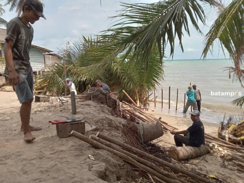 Warga Desa Sedamai memasang karung berisi pasir di bibir pantai untuk menahan abrasi yang mengancam badan jalan, Kamis (12/2). F. Encek Syarif untuk Batam Pos.