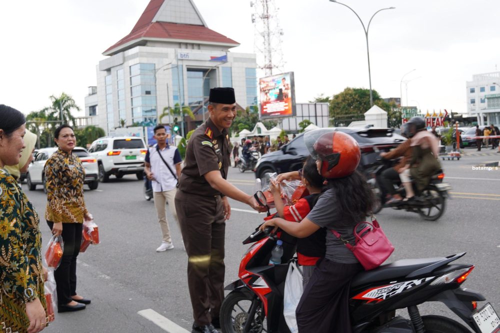 Kepala Kejaksaan Negeri Batam, I Wayan Wiradarma membagikan takjil kepada pengendara yang melintas di kawasan Engku Putri, Batam Center. F. Aziz Maulana/Batam Pos