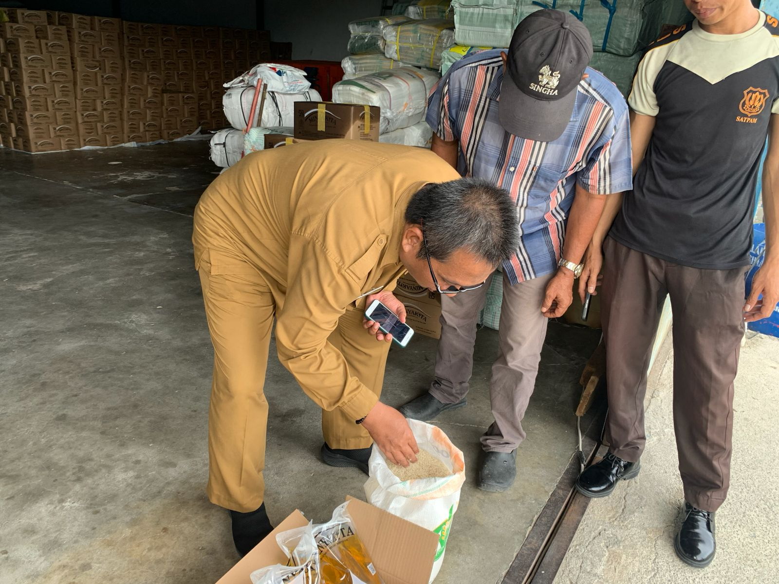 Kepala Dinas Pangan dan Pertanian Kabupaten Karimun melakukan uji mutu fisik beras&nbsp;secara visual sebelum disalurkan ke penerima bantuan pangan, Senin (9/3/2026). F Sandi Pramosinto/Batam Pos