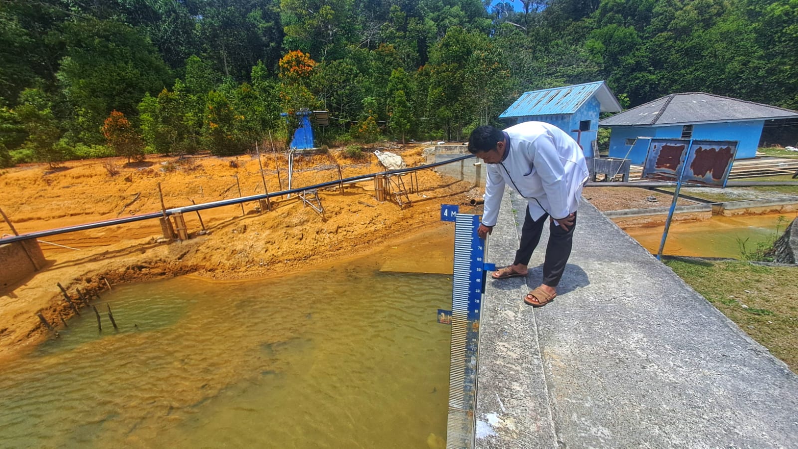 Kasi Teknik PDAM Tirta Kepri Cabang Tanjunguban, Kandar menunjuk tinggi muka air Waduk Sei Jago Tanjunguban, pada Selasa (10/3/2026). F.Slamet Nofasusanto/Batam Pos