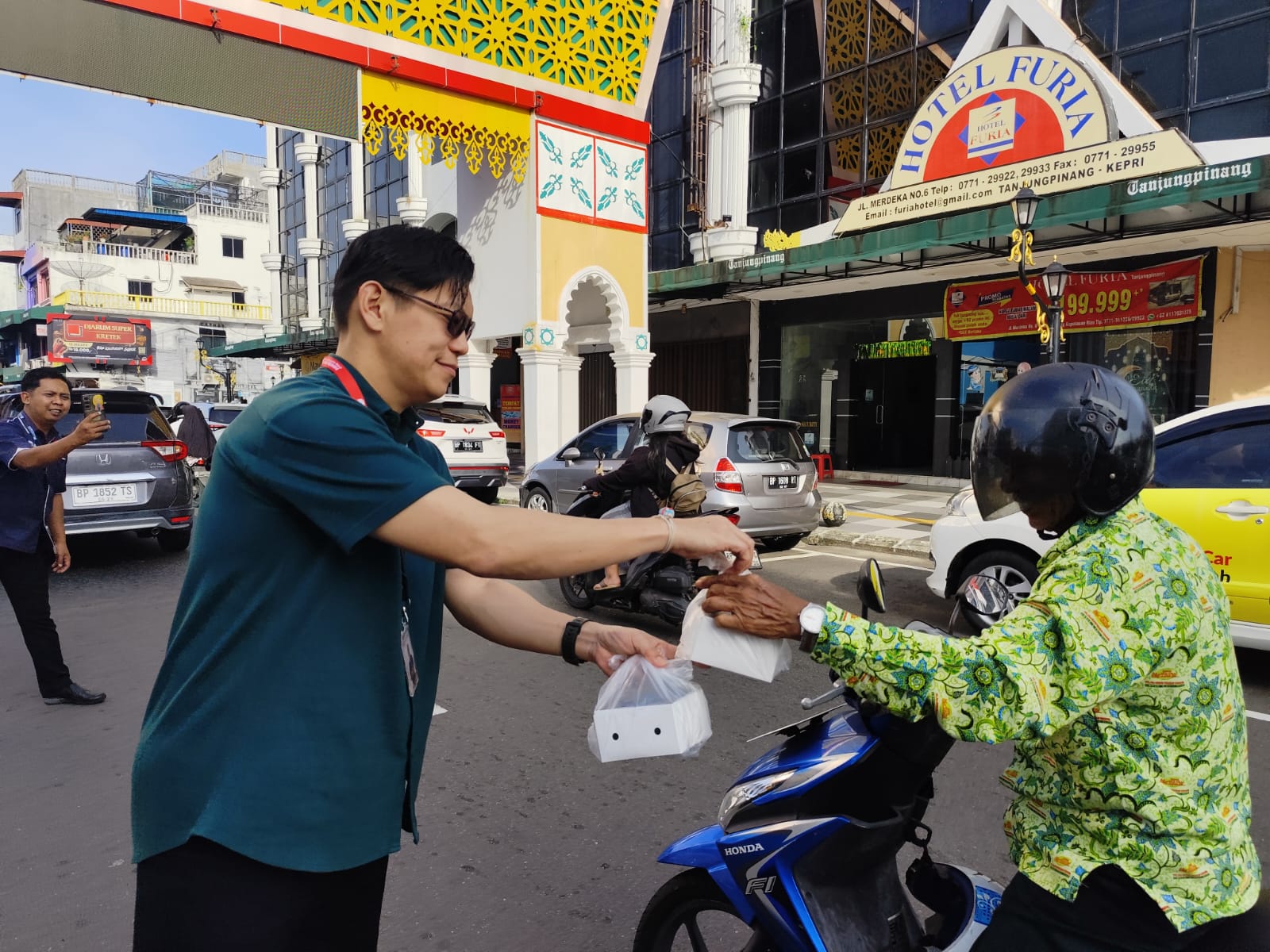 Direktur PT. BPR DMS Tanjungpinang, Wei Kiong saat membagikan paket takjil untuk pengendara di Jalan Merdeka Tanjungpinang, Selasa (11/3). F. Mohamad Ismail/Batam Pos