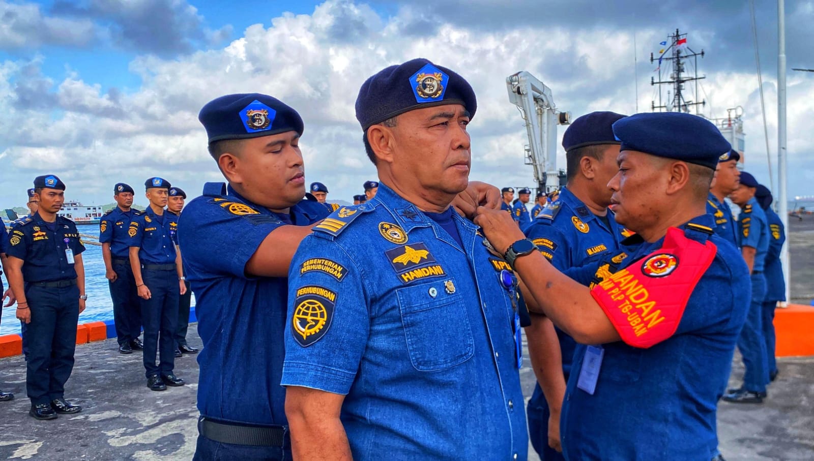 Plt Kepala Pangkalan PLP Tanjunguban, Alfaizul memasang bet tanda pengawasan dan pengamanan angkutan laut Lebaran 2026 kepada personel di Dermaga Pangkalan PLP Kelas II Tanjunguban, Jumat (13/3).