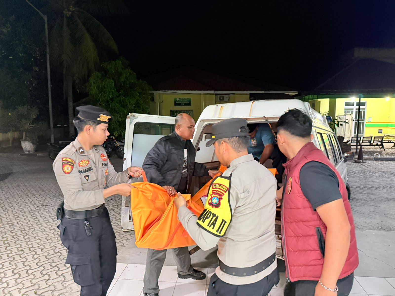 Polisi membawa mayat tanpa identitas ke ruang jenazah RSUD Muhammad Sani Karimun.   