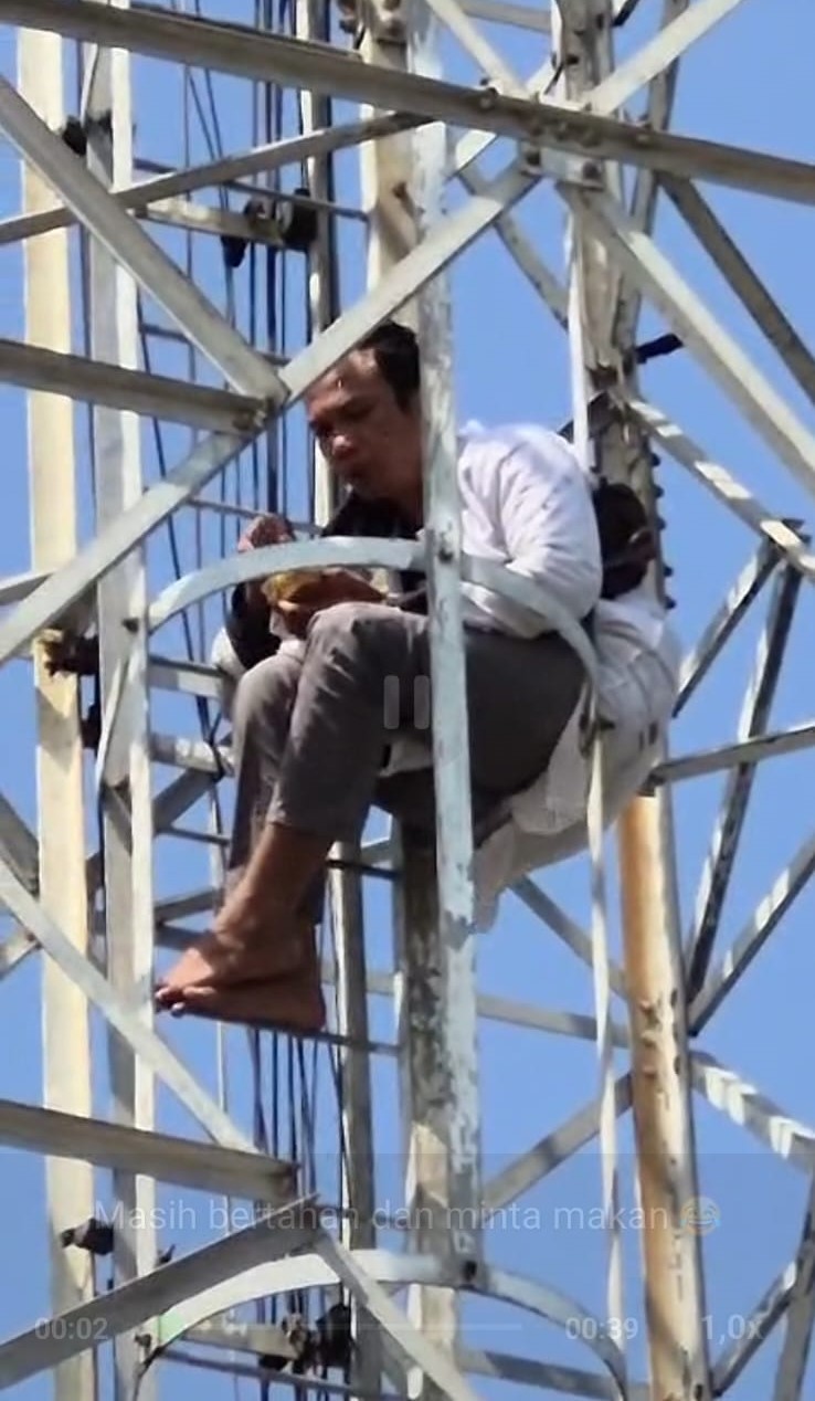 Pria bernama Iman yang memanjat tower di Sekupang Batam masih bertahan hingga siang hari, Kamis (26/3). F. Istimewa